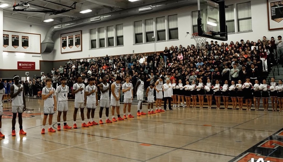 Cal High Varsity team lined up for the national anthem with packed student section behind them